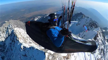 Go deep in Lijiang: Paraglider flies over Jade Dragon