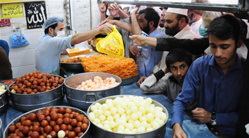 Pakistani people buy traditional sweets during Eid al-Fitr holiday 
